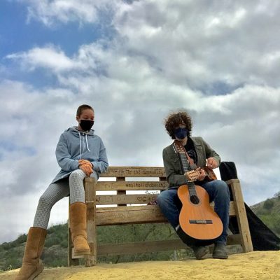 Image of musicians Claire and Theo on a bench with a guitar