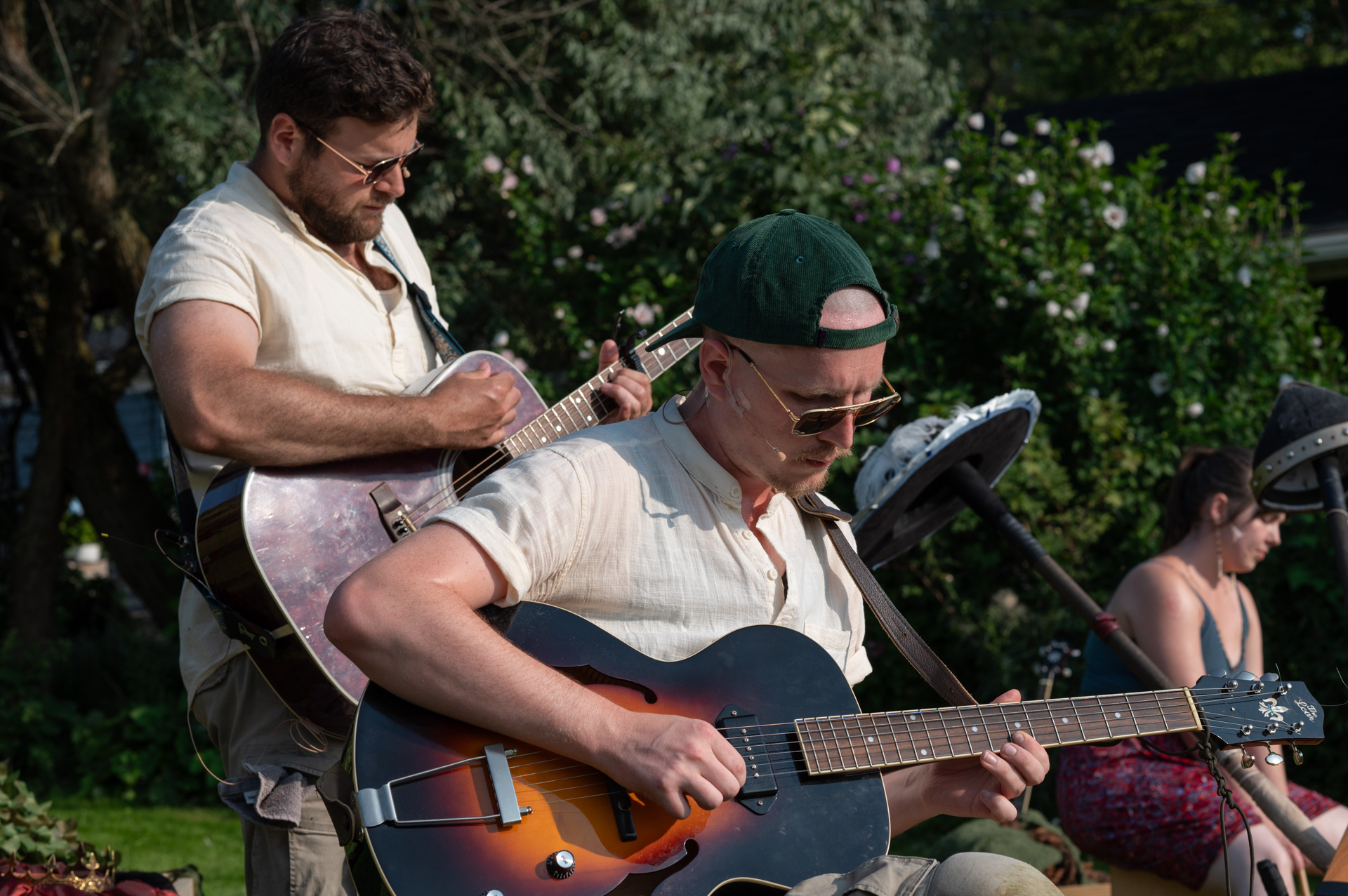 Two men playing guitars in a band performance.